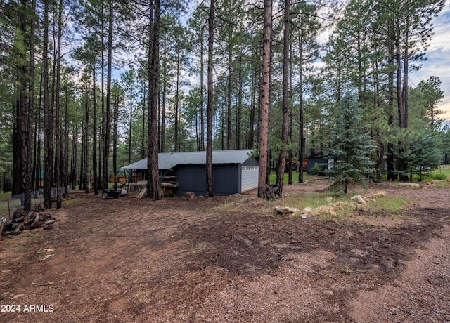 view of yard with a detached garage and an outbuilding