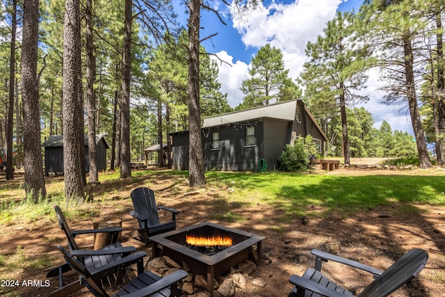 view of yard featuring an outdoor fire pit and an outdoor structure