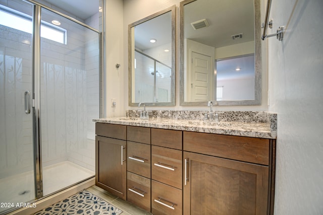 bathroom featuring tile patterned floors, dual bowl vanity, and an enclosed shower