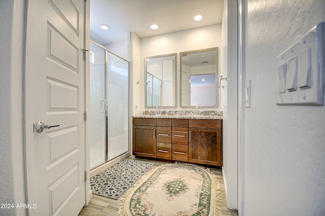 bathroom featuring double vanity and an enclosed shower