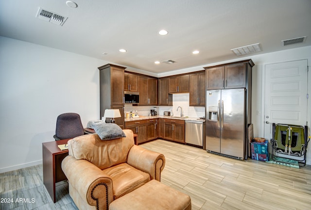 kitchen featuring light hardwood / wood-style flooring, dark brown cabinetry, tasteful backsplash, sink, and stainless steel appliances