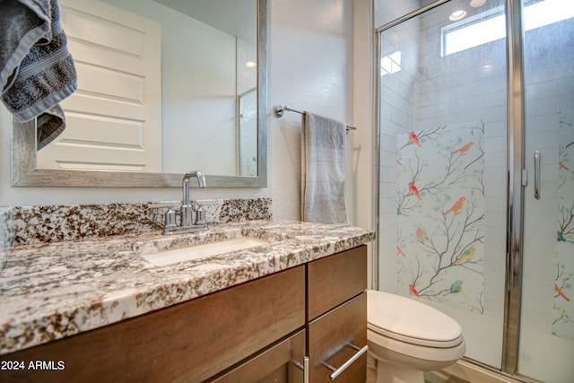 bathroom with toilet, walk in shower, and vanity