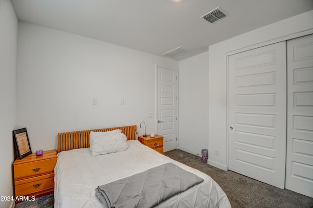 bedroom with a closet and dark colored carpet