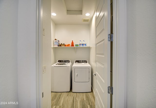 laundry room featuring washer and clothes dryer and light wood-type flooring