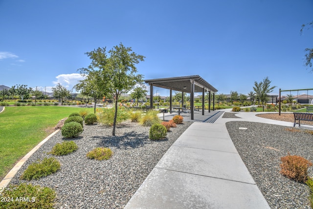 view of property's community featuring a lawn and a pergola