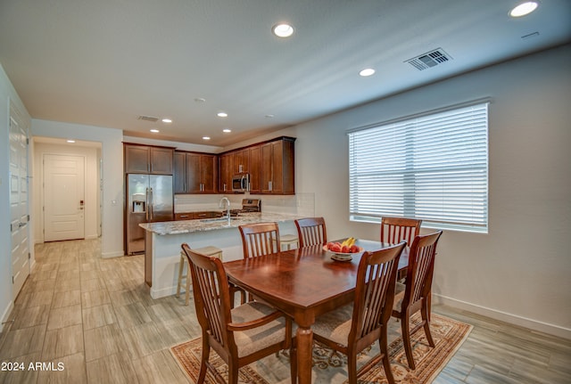 dining space featuring sink and light hardwood / wood-style flooring