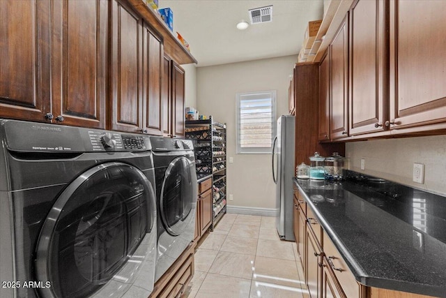 washroom with cabinet space, separate washer and dryer, baseboards, and visible vents