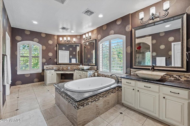 bathroom with wallpapered walls, visible vents, a tub with jets, and a sink