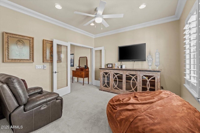 living area with carpet flooring, ceiling fan, crown molding, and french doors
