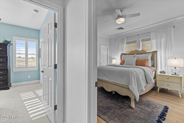 bedroom featuring crown molding, a ceiling fan, baseboards, and visible vents