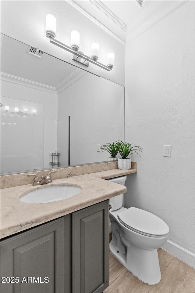 bathroom with visible vents, ornamental molding, wood finished floors, and vanity