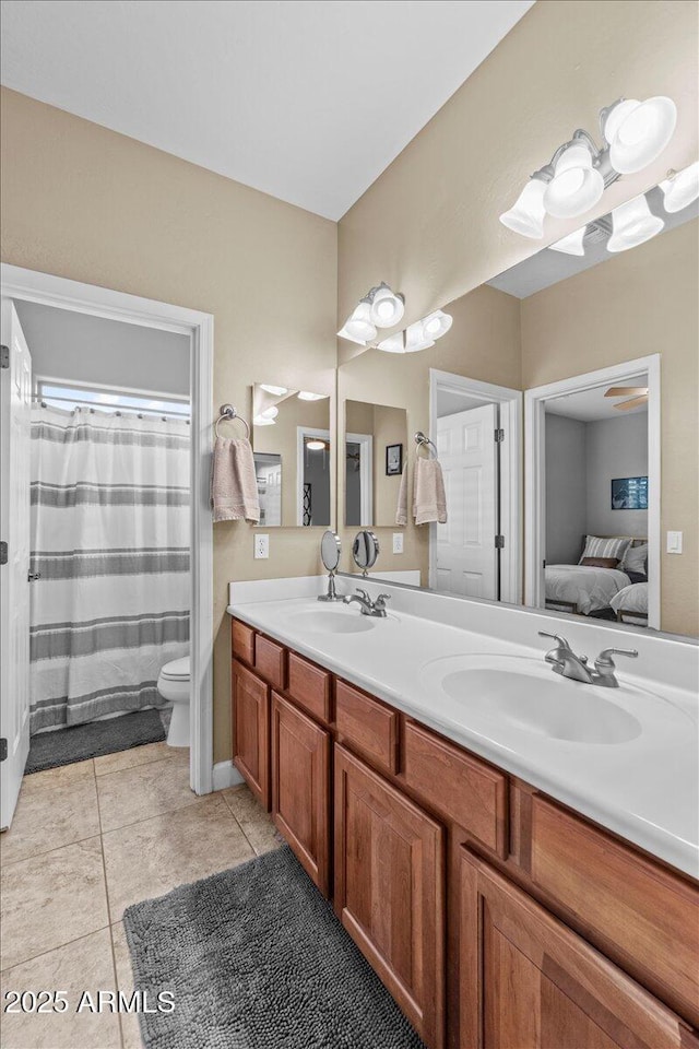 ensuite bathroom featuring double vanity, toilet, a sink, and ensuite bathroom