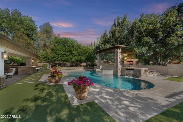 view of pool with an outdoor kitchen, a gazebo, a patio area, and a bar