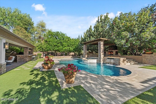 view of swimming pool featuring outdoor dry bar, a pool with connected hot tub, an outdoor stone fireplace, a patio area, and a yard