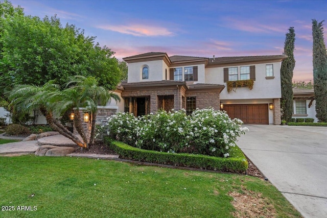 prairie-style house with an attached garage, stucco siding, a front yard, and concrete driveway