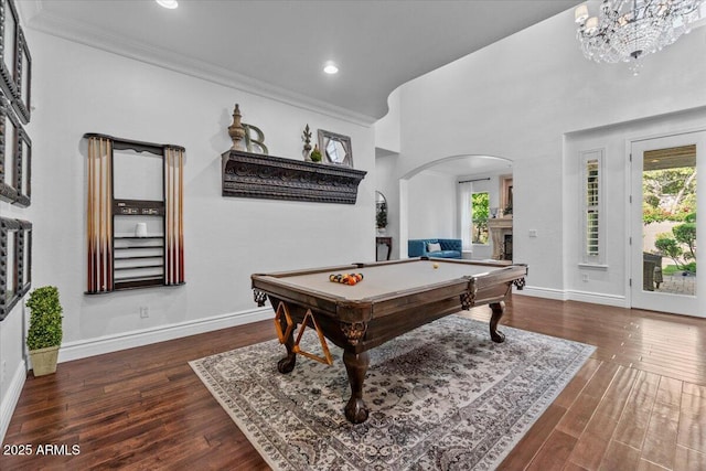 playroom featuring a fireplace, arched walkways, ornamental molding, and baseboards
