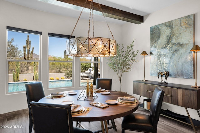dining room with wood finished floors, beam ceiling, and a chandelier