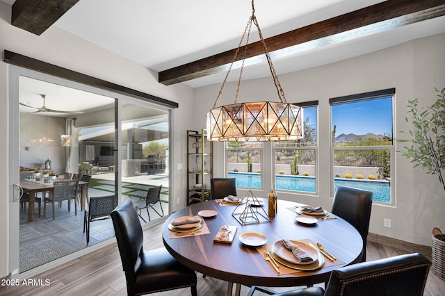 dining space with beam ceiling, a chandelier, healthy amount of natural light, and wood finished floors