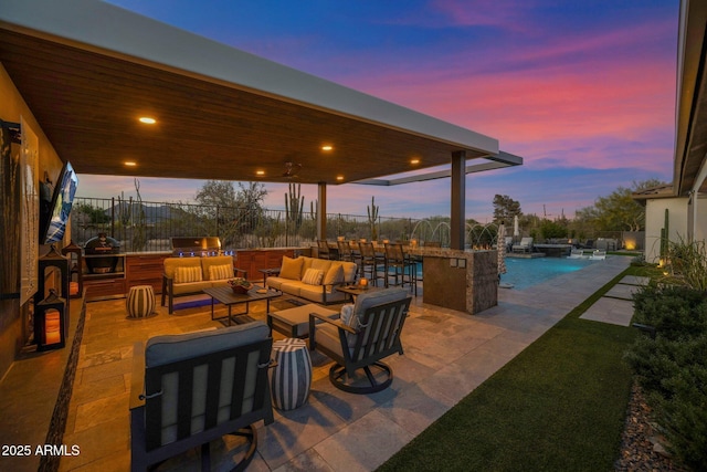 patio terrace at dusk featuring an outdoor living space and an outdoor pool