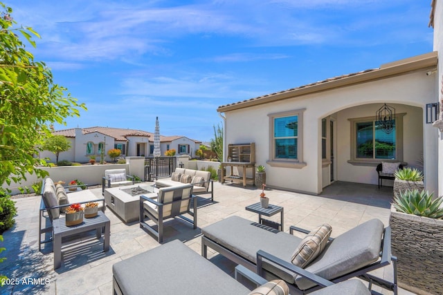 view of patio with an outdoor living space with a fire pit