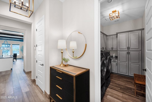laundry room featuring cabinet space, washing machine and dryer, and dark wood finished floors