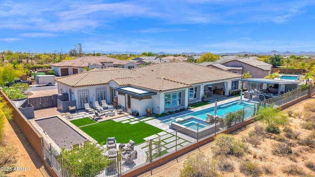 back of property featuring a fenced backyard, an outdoor living space, a patio area, a pool with connected hot tub, and a tile roof