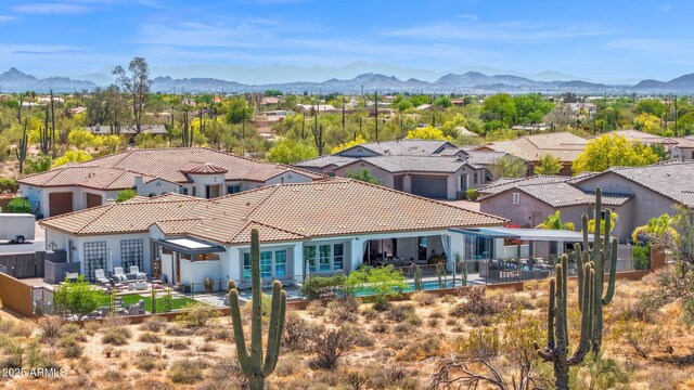 rear view of house featuring a mountain view, a fenced backyard, a tile roof, and a patio area