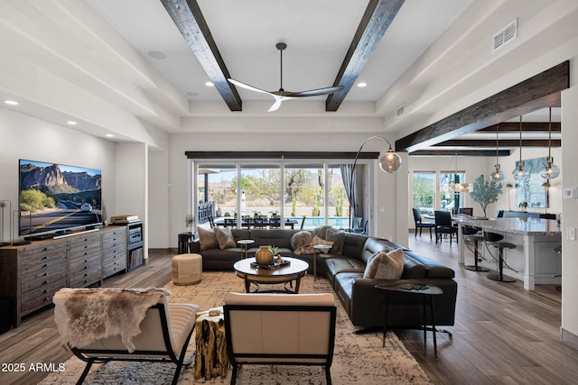 living room featuring beam ceiling, wood finished floors, and recessed lighting