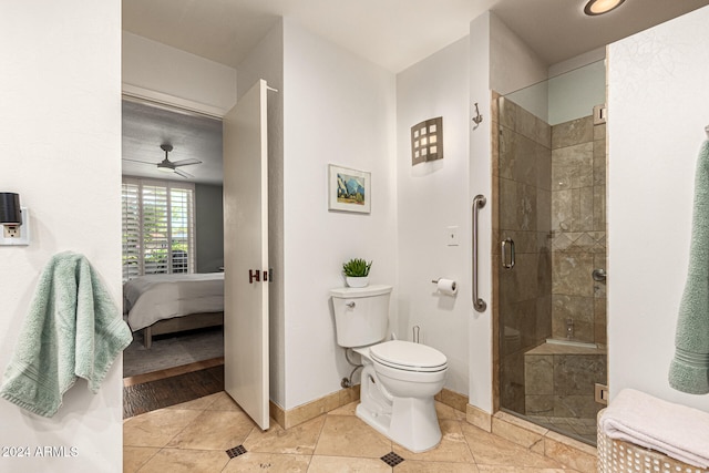 bathroom featuring toilet, tile patterned floors, a shower with door, and ceiling fan