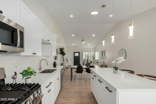 kitchen featuring a sink, stainless steel appliances, light wood-style floors, and light countertops