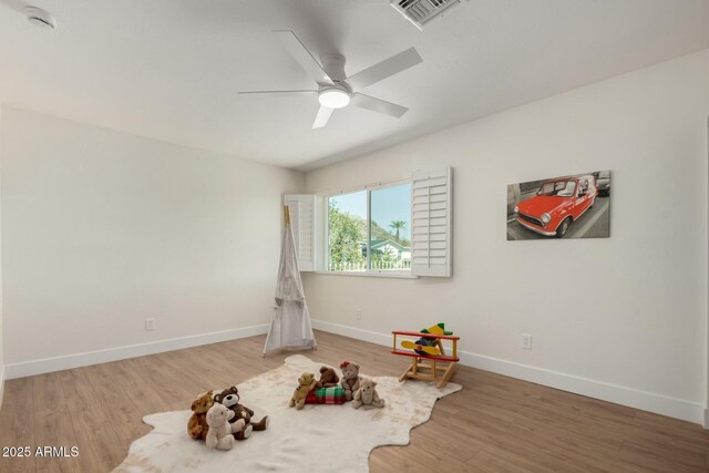 recreation room with visible vents, baseboards, wood finished floors, and a ceiling fan