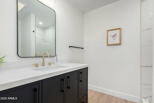 full bath featuring a shower, baseboards, wood finished floors, and vanity