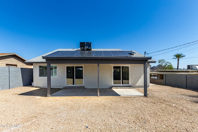 rear view of property with metal roof, a patio, a fenced backyard, and stucco siding