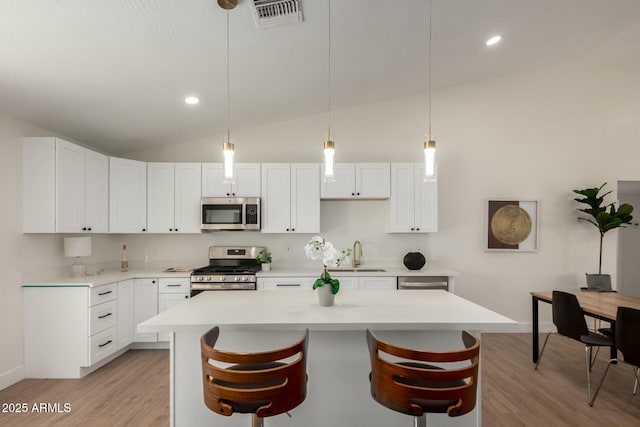 kitchen featuring visible vents, a sink, light countertops, light wood-style floors, and appliances with stainless steel finishes