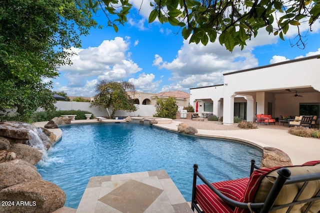 view of swimming pool featuring pool water feature, ceiling fan, an outdoor living space, and a patio