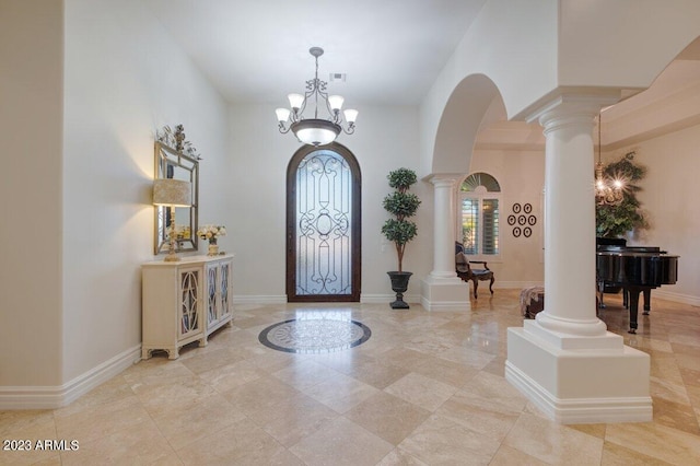 foyer with decorative columns and a chandelier