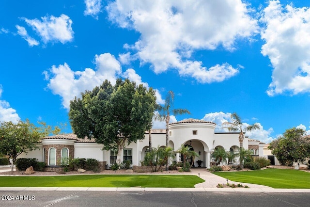 mediterranean / spanish home featuring a front lawn