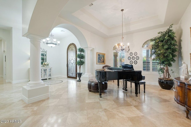 miscellaneous room featuring a tray ceiling and ornate columns