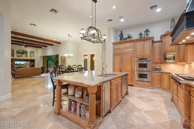 kitchen featuring sink, custom exhaust hood, appliances with stainless steel finishes, a kitchen breakfast bar, and an island with sink