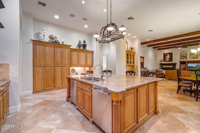 kitchen featuring decorative light fixtures, sink, a kitchen island with sink, stainless steel dishwasher, and light stone counters