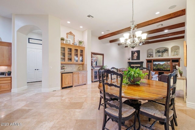 dining space with beam ceiling and a chandelier