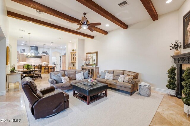 living room with beam ceiling and ceiling fan with notable chandelier