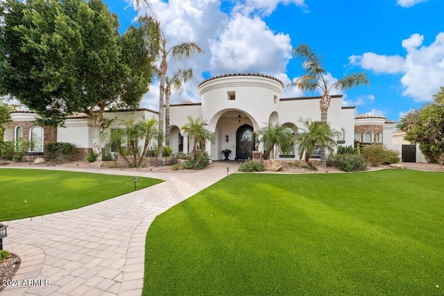 mediterranean / spanish-style home featuring a front yard