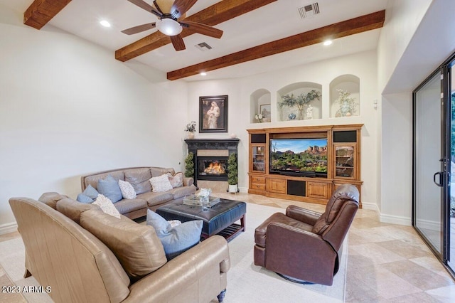 living room featuring beamed ceiling, ceiling fan, and a fireplace