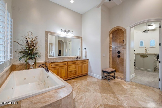 bathroom with independent shower and bath, vanity, a high ceiling, and ceiling fan