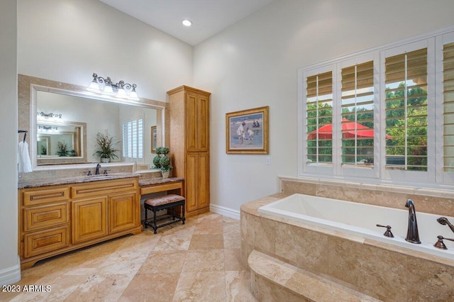 bathroom featuring vanity and tiled tub