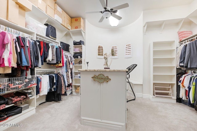 walk in closet with ceiling fan and light carpet