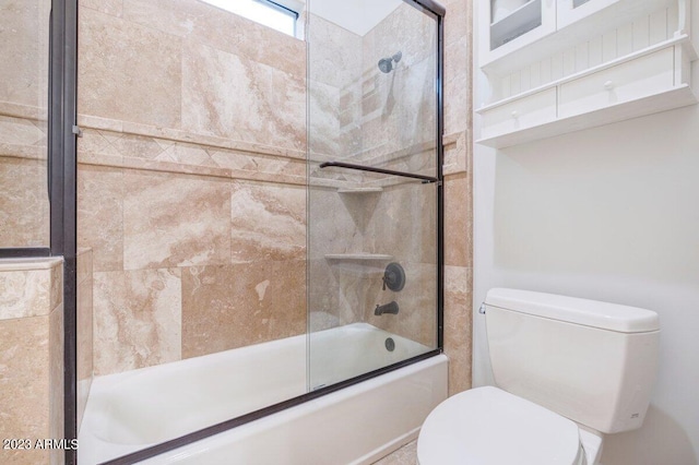 bathroom featuring combined bath / shower with glass door and toilet