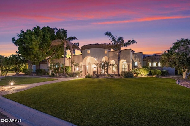 mediterranean / spanish house featuring a yard