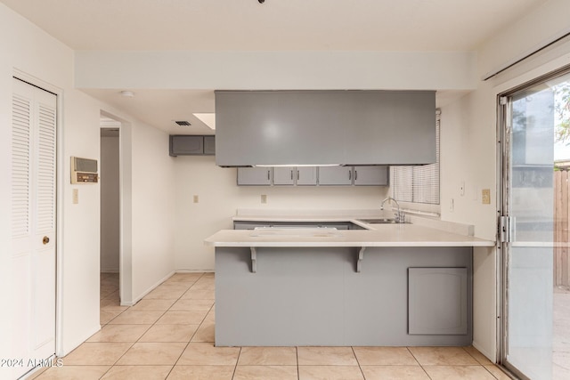 8027 N 32nd Ave, Phoenix, AZ 85051 - kitchen featuring gray cabinets, a sink, a peninsula, and light tile patterned floors